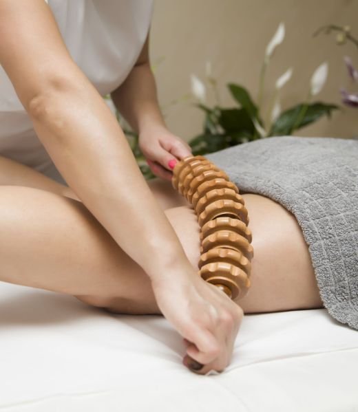 Closeup of the maderotherapy anti-cellulite massage with wooden roller massager